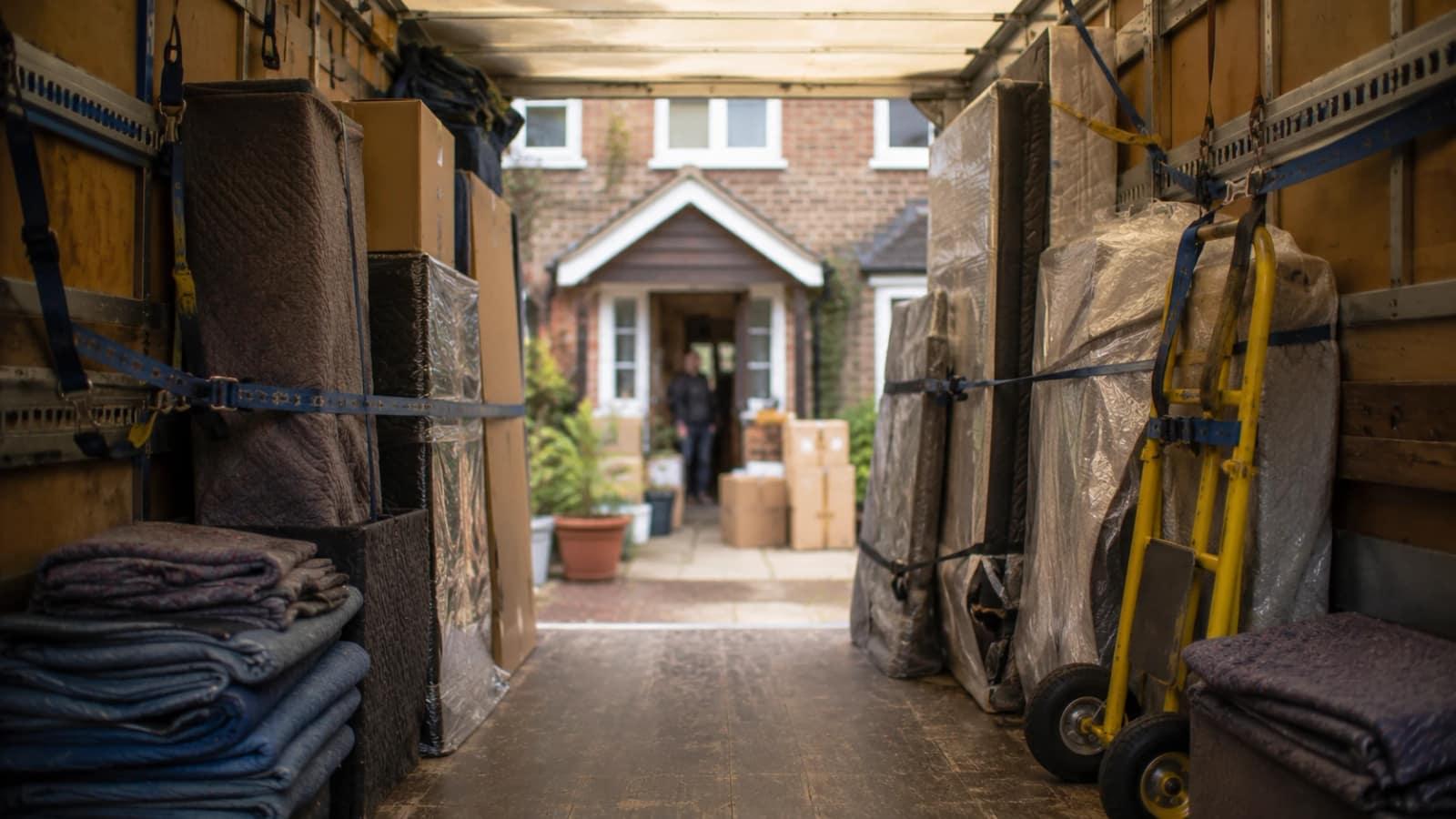 Inside a loaded removals van looking out at the house on moving day